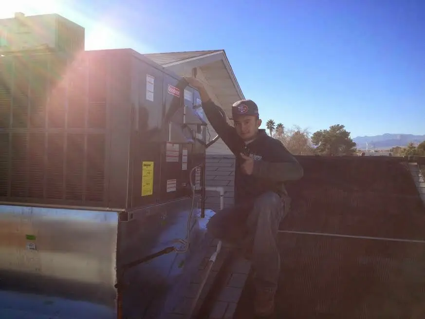 HVAC technician performing HVAC Inspection on a rooftop unit in Three Oaks